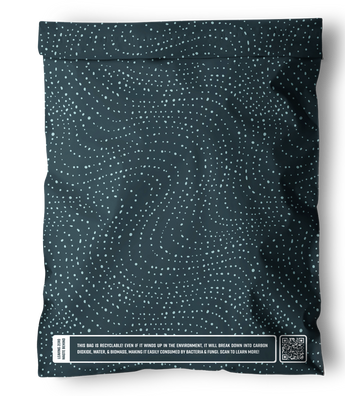 The impack.co SALE - Wavy Dots Biodegradable Mailer (19" x 24") is an extra-large, dark mailer with a white dotted pattern and a rectangular label at the bottom featuring sustainability info and a QR code.