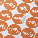 Orange circular stickers with "nolly" in white, neatly arranged in a grid pattern on impack.co's Custom Paper Sticker Sheets - Single design, with one sticker partially peeled off.
