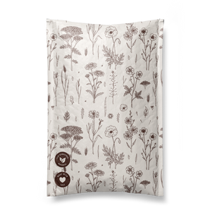 A beige bag with brown floral line drawings, featuring two circular logos at the bottom, is perfect for carrying fragile items. This stylish accessory keeps your belongings secure, similar to how impack.co's Wildflower Biodegradable Bubble Mailers 6" x 9" provide protection during transit.
