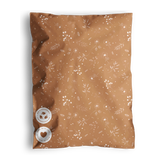 Decorative brown throw pillow with white botanical pattern and two impack.co Floral 2D Chestnut Biodegradable Mailers 12" x 15.5" as buttons.