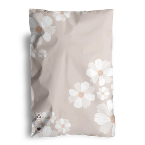 A beige pillowcase featuring white and light brown floral designs, softly echoing the Cosmos print of the impack.co biodegradable mailers.