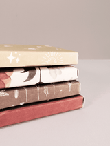 A stack of ABC Box Wildflower 7" x 8" - Large books with different designs on them, ready for shipping from impack.co.