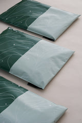 Three Japanese Green Mailers 10" x 13" from impack.co with versatile patterns in green and light blue rest on a light surface, offering style and transit protection.