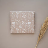 An impack.co ABC Box Wildflower 7" x 8" - Large with a wildflower print on it and a stalk of grass.