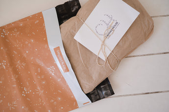 A Floral 2D Chestnut Biodegradable Mailers 12" x 15.5" from impack.co with a note inside.