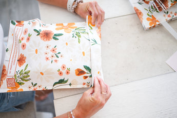 A woman is creating a Gardenlumina Padded Paper Mailers 10" x 13" bag from impack.co.