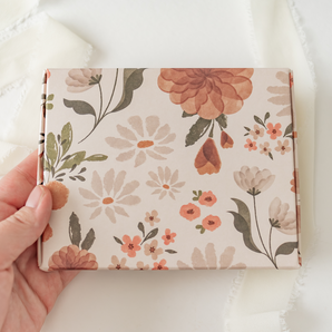 A hand holding an impack.co Gardenlumina print-patterned ABC Box 4.8" x 6" - Medium book or journal.