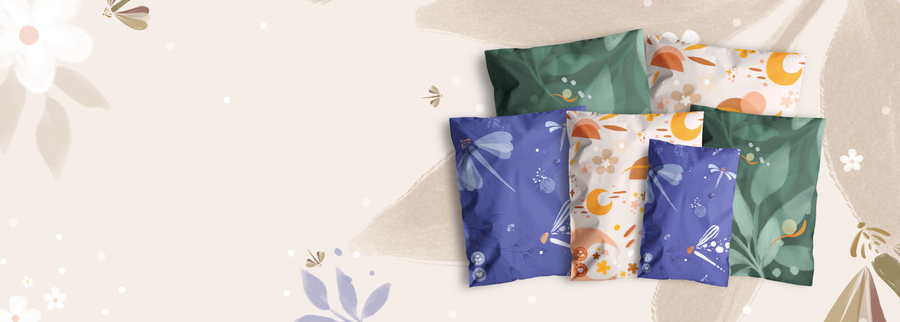 A collection of six decorative pillows with floral and abstract nature patterns in green, blue, and beige tones, arranged on a light, patterned background.