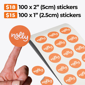 A hand holds a round orange sticker featuring the word "nolly." Below are many similar stickers on an uncoated paper sheet from impack.co's "Custom Paper Sticker Sheets - Single design" collection. Pricing displayed is: $18 for 100 x 2-inch (5cm) stickers and $15 for 100 x 1-inch (2.5cm) stickers, making them ideal for personalized packaging.