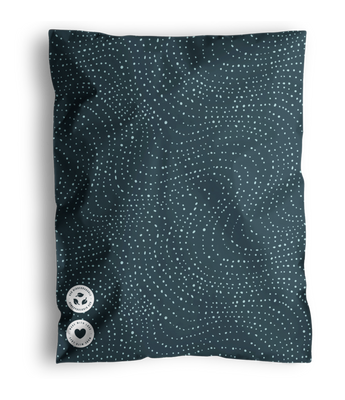 A blue pillow with a dotted wavy pattern and two buttons, shipped in impack.co's Wavy Dots Biodegradable Mailers 19" x 24%.