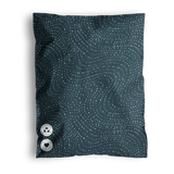 A blue pillow with a dotted wavy pattern and two buttons, shipped in impack.co's Wavy Dots Biodegradable Mailers 19" x 24%.