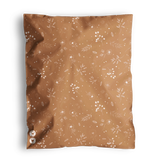 A brown, 100% recyclable Floral 2D Chestnut Biodegradable Mailers 14.5" x 19" square with a floral pattern and two visible white buttons, slightly folded at the corner, set against a dark background by impack.co.