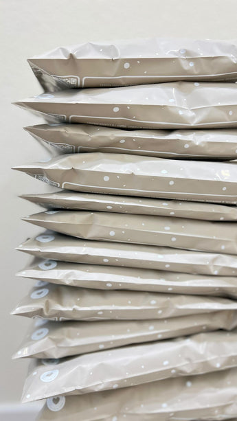 A side view of sandstone biodegradable mailers by impack.co neatly stacked, offering reliable transit protection for your items.