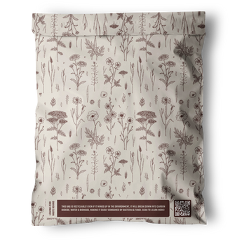 The Wildflower Biodegradable Mailers 12" x 15.5" by impack.co offer sealed, recyclable floral packaging with brown illustrations on cream and a boxed sustainability message beside a QR code—ideal for plastic-free packing.