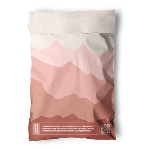 The Mountain Clay Mailers 6" x 9" by impack.co are biodegradable mailers with a pink mountain design, QR code, and notes on recyclability and eco benefits—ideal for sustainable packaging of small shipments.