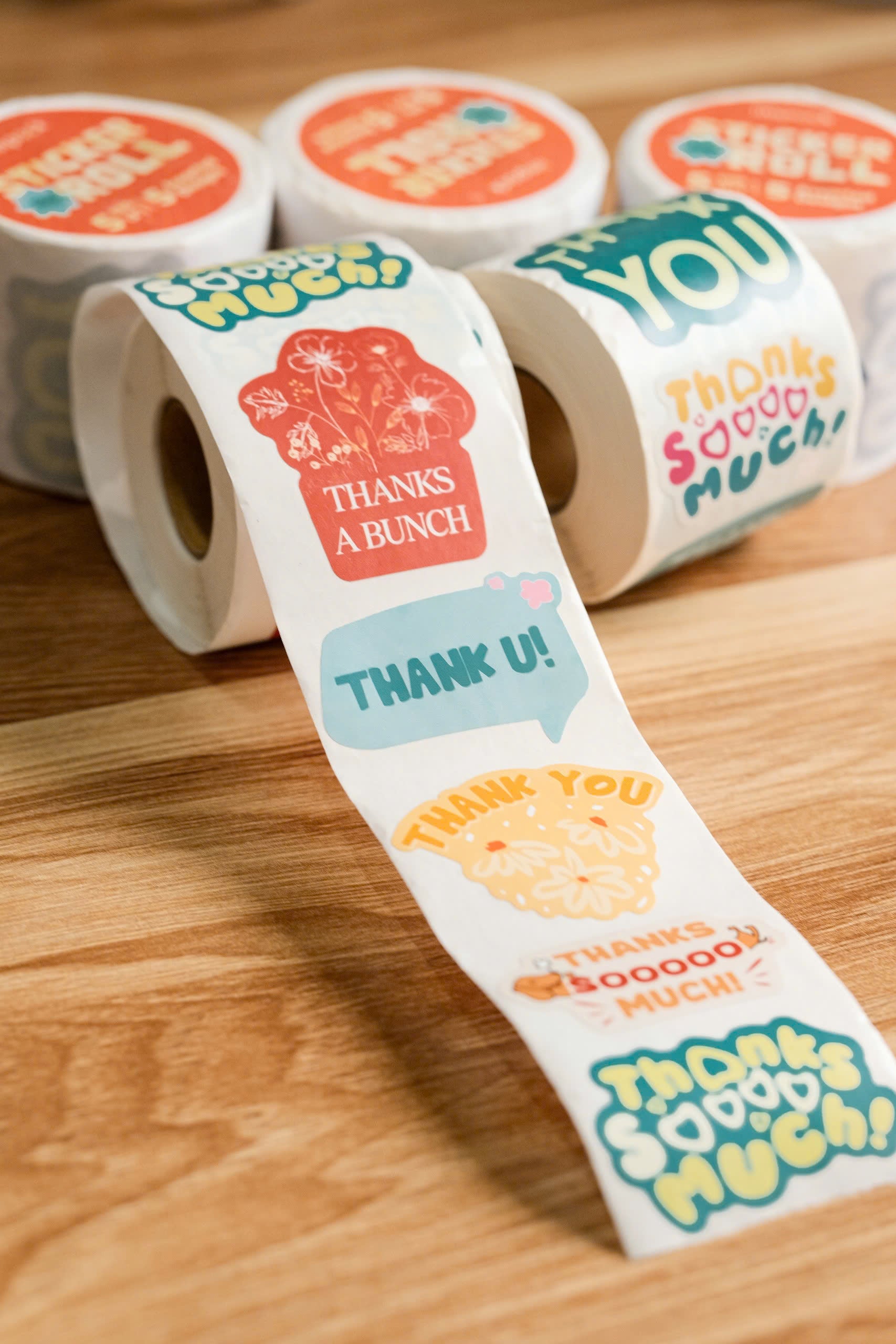 Rolls of colorful stickers with phrases like 