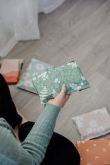A woman is sitting on the floor with a bunch of Biodegradable Mailers 6" x 9" in front of her.